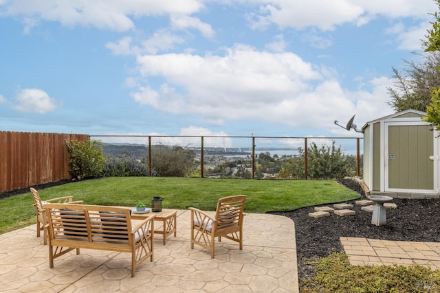 view of patio featuring a storage shed, a fenced backyard, outdoor lounge area, and an outbuilding