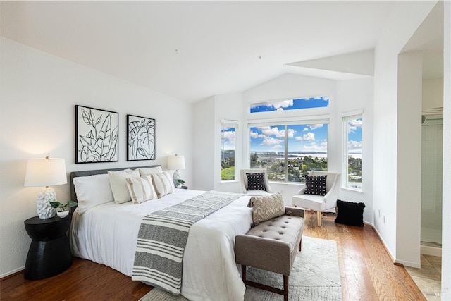 bedroom with baseboards, vaulted ceiling, and wood finished floors