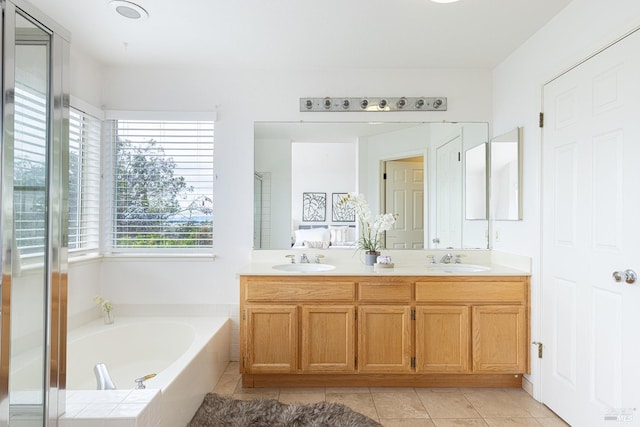 full bath featuring a sink, a shower stall, double vanity, and a bath