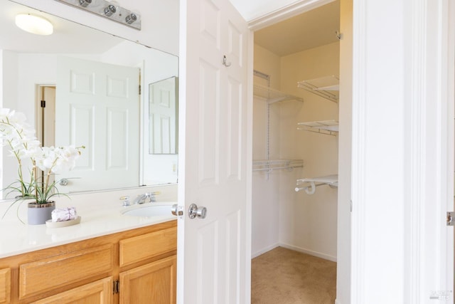 bathroom featuring a spacious closet and vanity