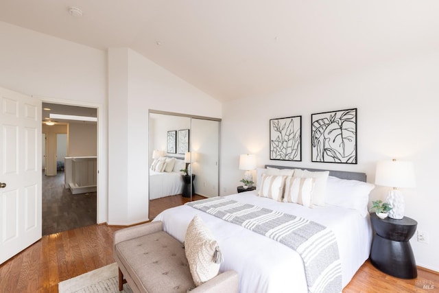 bedroom featuring a closet, high vaulted ceiling, and wood finished floors