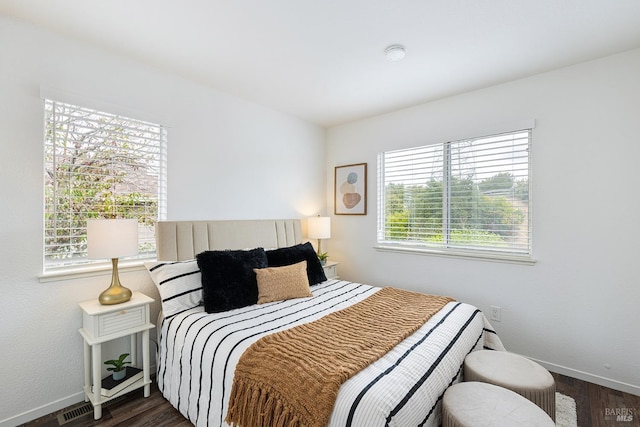 bedroom featuring dark wood-style floors, visible vents, and baseboards