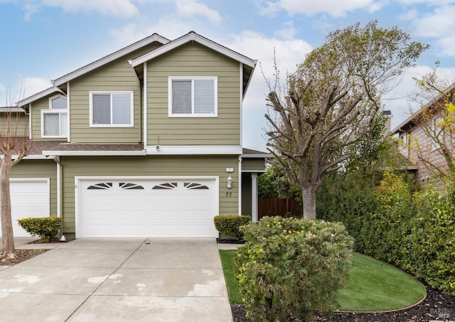 view of front facade featuring a garage, a shingled roof, and concrete driveway