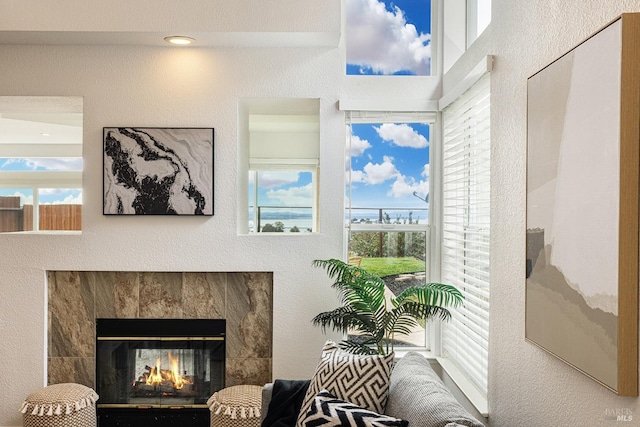 sitting room featuring a textured wall, a healthy amount of sunlight, and a fireplace