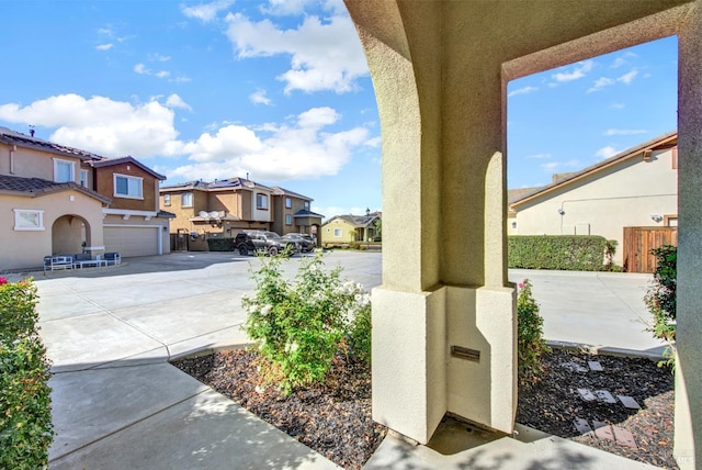 view of patio / terrace with a garage, a residential view, and concrete driveway