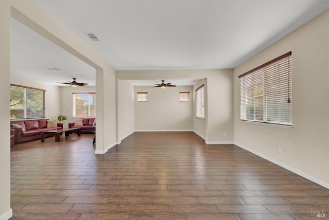 living area with a ceiling fan, baseboards, visible vents, and dark wood-type flooring