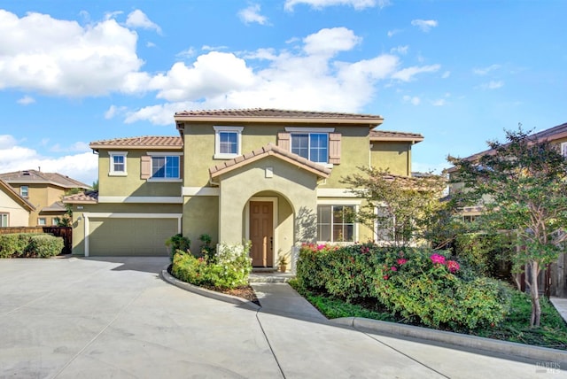 mediterranean / spanish home featuring driveway, a tile roof, an attached garage, fence, and stucco siding