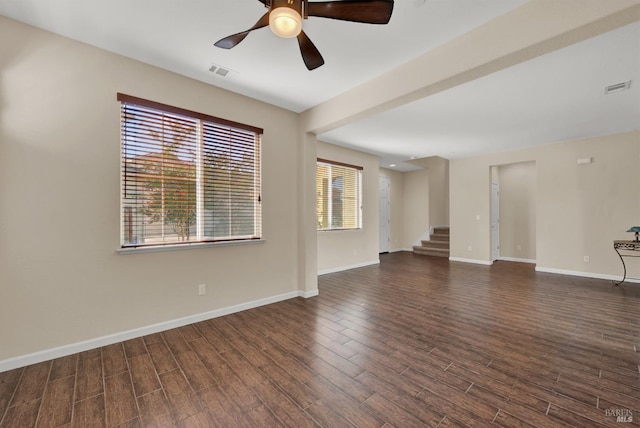 unfurnished room with dark wood-style floors, visible vents, and baseboards