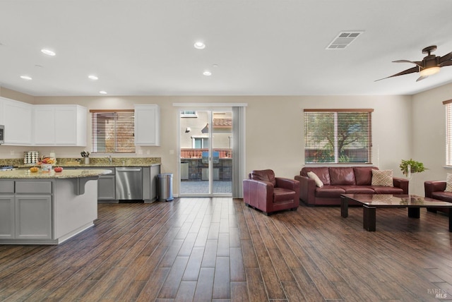 living room featuring a ceiling fan, visible vents, dark wood-style flooring, and recessed lighting