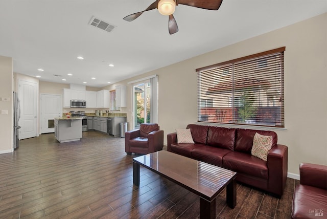 living area featuring recessed lighting, dark wood-style flooring, visible vents, and baseboards