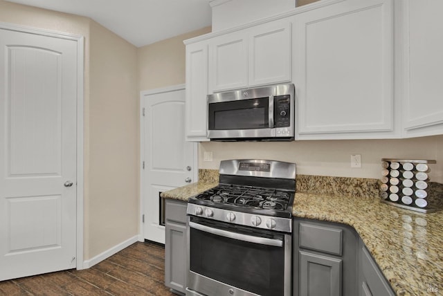 kitchen featuring stainless steel appliances, dark wood-type flooring, white cabinets, gray cabinets, and light stone countertops