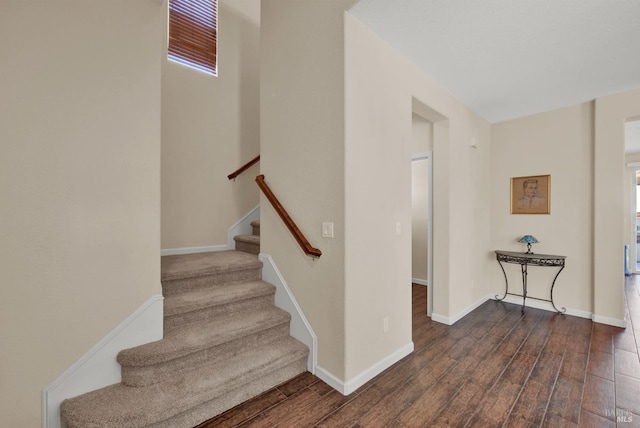 stairway with baseboards and wood finished floors