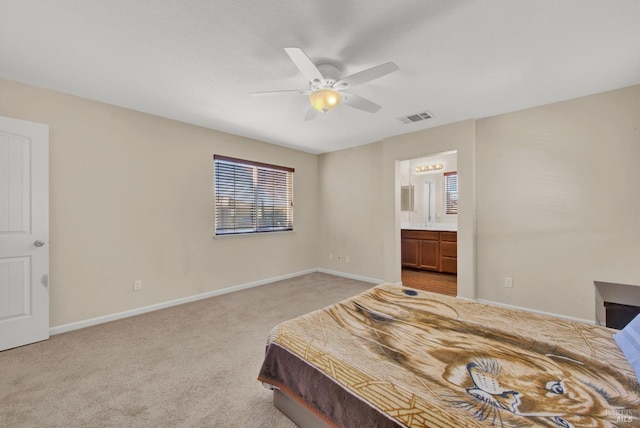 bedroom with baseboards, visible vents, connected bathroom, light colored carpet, and ceiling fan