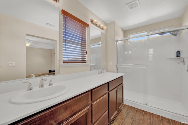 bathroom featuring plenty of natural light, visible vents, a sink, and wood finished floors