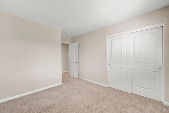 unfurnished bedroom featuring a closet, carpet, and baseboards