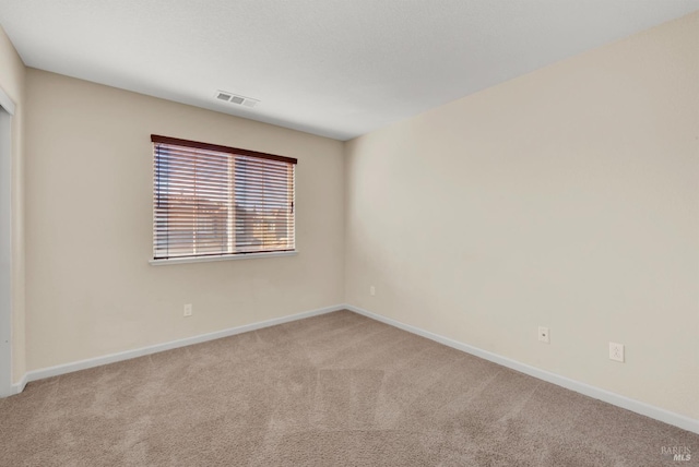 unfurnished room featuring carpet floors, visible vents, and baseboards