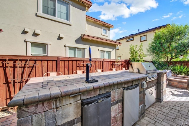 view of patio / terrace featuring an outdoor kitchen, a fenced backyard, and grilling area