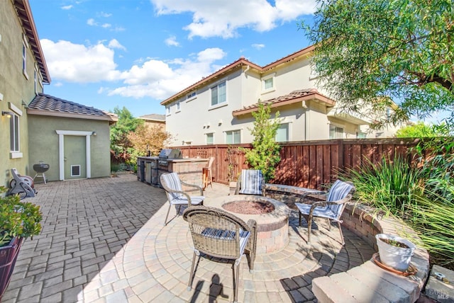 view of patio / terrace with a fire pit, area for grilling, and fence