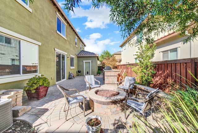 view of patio featuring an outdoor fire pit, fence, and central AC