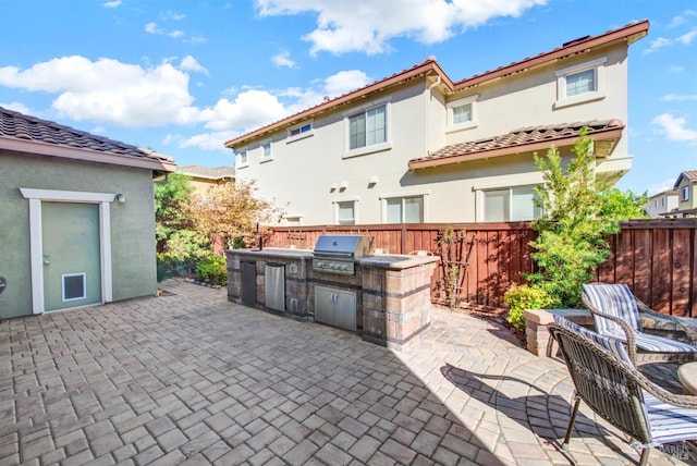 view of patio with a grill, fence, and area for grilling