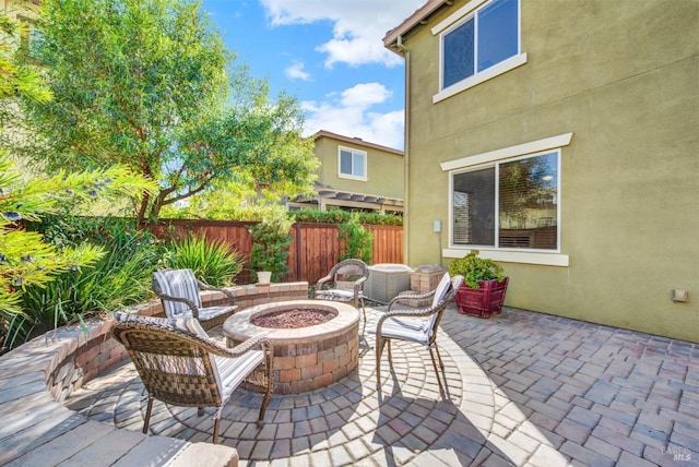 view of patio with an outdoor fire pit and fence