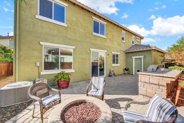 back of house featuring fence, central AC unit, a patio, and stucco siding