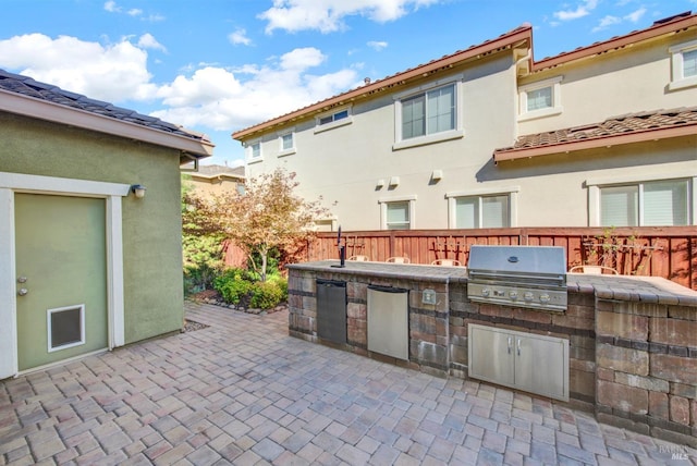 view of patio with fence, an outdoor kitchen, and area for grilling