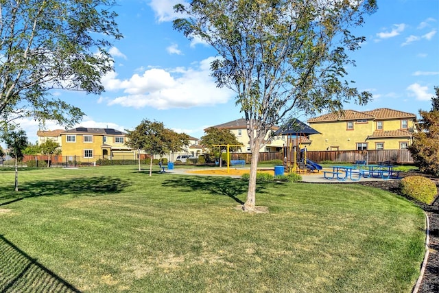 view of yard featuring playground community and fence