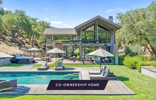 back of house featuring a yard, a chimney, an outdoor hangout area, a deck, and an outdoor pool