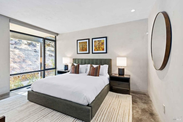 bedroom with floor to ceiling windows and carpet flooring