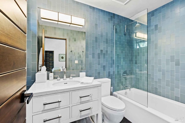 full bathroom with shower / washtub combination, tile walls, toilet, and vanity