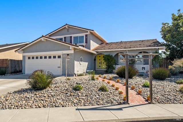 traditional-style home featuring driveway, fence, and stucco siding