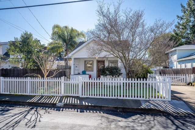 bungalow-style house featuring a porch and a fenced front yard