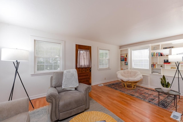 living room with visible vents, baseboards, and wood finished floors