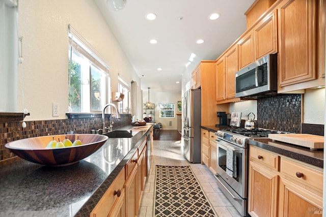 kitchen featuring light tile patterned floors, tasteful backsplash, stainless steel appliances, a sink, and recessed lighting