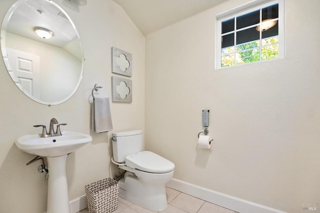 bathroom featuring baseboards, a sink, toilet, and tile patterned floors