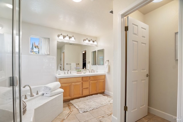 full bathroom with a garden tub, double vanity, a sink, and tile patterned floors