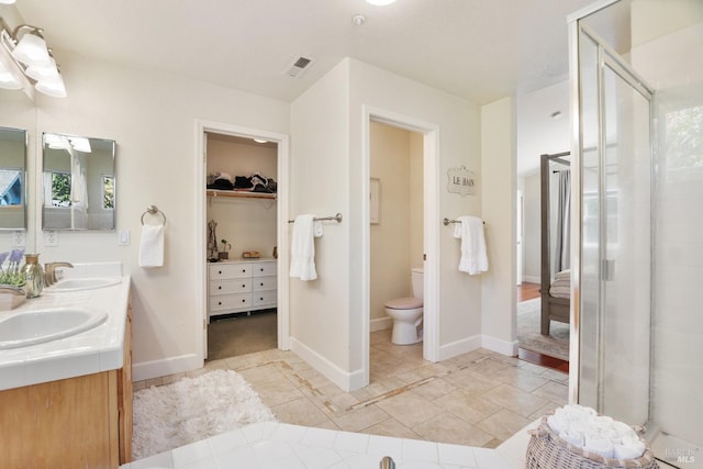 bathroom featuring visible vents, a sink, toilet, and tile patterned floors