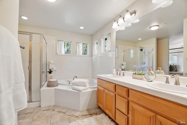 full bath featuring a garden tub, a sink, and a stall shower