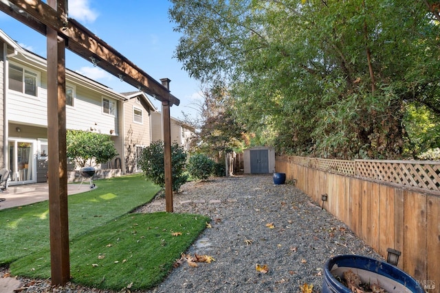 view of yard featuring an outbuilding, a patio, a storage unit, and a fenced backyard