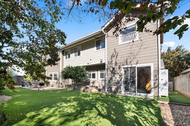 back of house featuring a patio area, a yard, and a fenced backyard