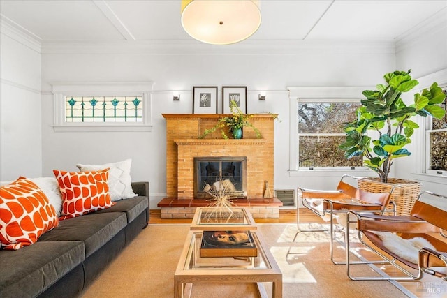 living room featuring ornamental molding, a brick fireplace, a healthy amount of sunlight, and wood finished floors