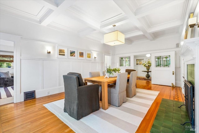 dining room featuring beamed ceiling, coffered ceiling, visible vents, and light wood-style floors