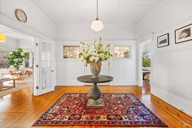 interior space with light wood-style floors, crown molding, and baseboards