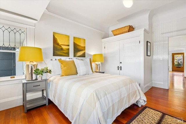 bedroom featuring a closet, wood finished floors, and baseboards