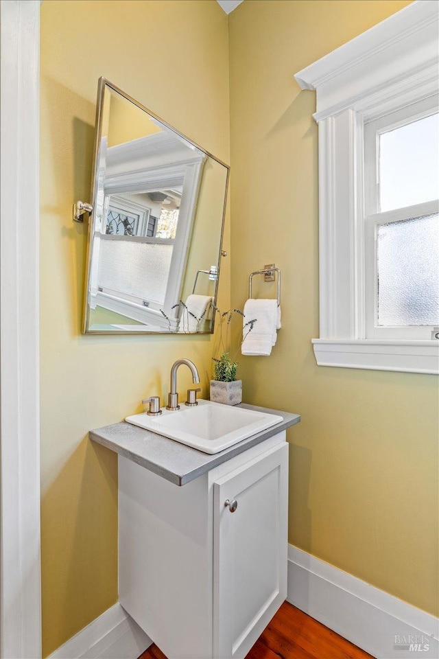 bathroom with vanity, baseboards, and wood finished floors