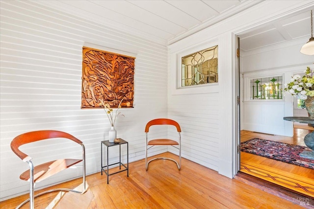 living area featuring light wood-style floors and crown molding