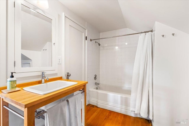 full bath featuring wood finished floors, vanity, and shower / bathtub combination with curtain