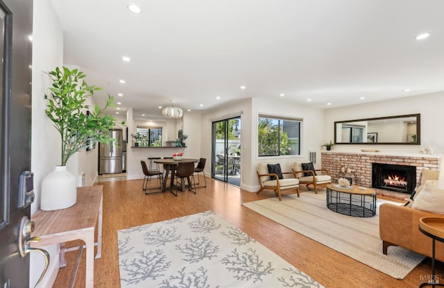 living room with a fireplace, baseboards, wood finished floors, and recessed lighting