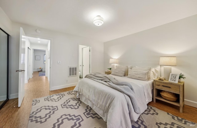 bedroom with visible vents, baseboards, and wood finished floors